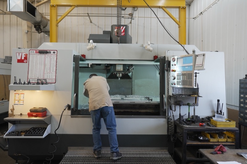 Machinist loading a part into a Haas vertical mill